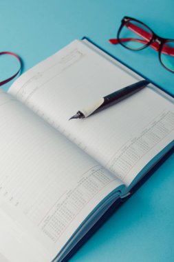 Mavi kağıt üzerine not defteri. Açık günlüğü ve kaydetmek için kalem