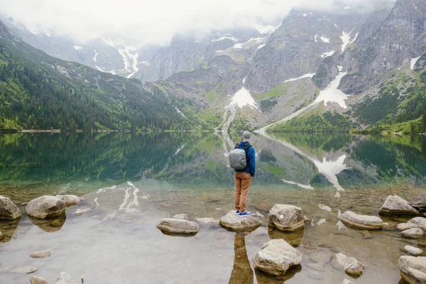 Muž relaxační na jezeře a hory slunné krajiny — Stock fotografie