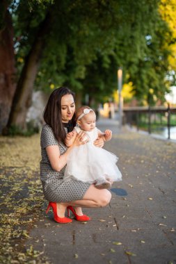 Parktaki mutlu anne ve kız. Aile hayatı olan güzel doğa manzarası. Mutlu bir aile yeşil çimlerin üzerinde birlikte dinleniyor, dışarıda eğleniyor. Aile hayatında mutluluk ve uyum.