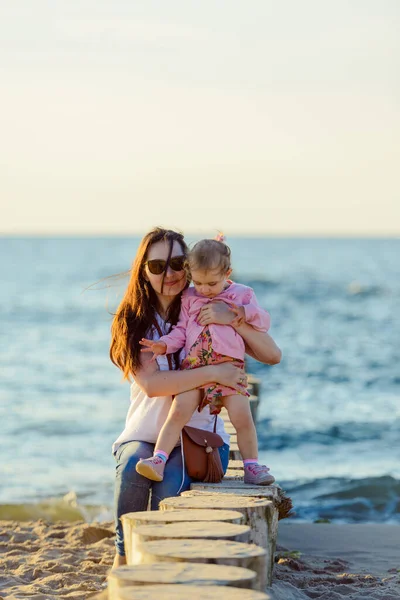 Moeder en dochtertje spelen op het strand. Authentiek beeld — Stockfoto