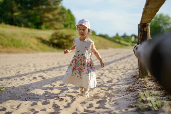 Adorable niña en una playa de arena soleada. Auténtica infancia. — Foto de Stock