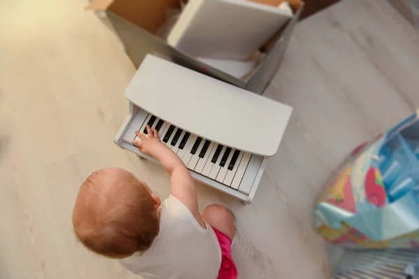 Hermosa niña jugando piano de juguete en la sala de luz. Auténtico i —  Fotos de Stock