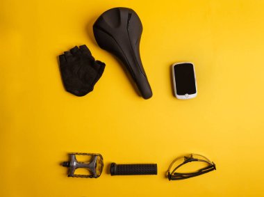 Sarı arka planda bisiklet, bisiklet aksesuarları. Yukarıdan görünüm.