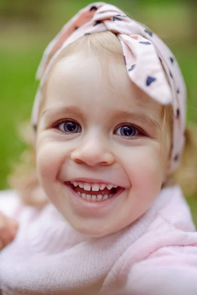 Hermosa niña sonriendo en un día soleado. Ojos azules. disparo en la cabeza —  Fotos de Stock