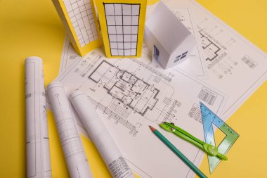 Beyaz aile kağıt evi, ev projeleri planı ve arka planda planlar. Minimalist ve basit bir kavram, tarz. Yatay oryantasyon. Yukarıdan görüntüle.