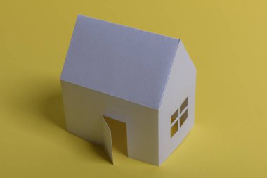 Beyaz aile kağıt evi, ev projeleri planı ve arka planda planlar. Minimalist ve basit bir kavram, tarz. Yatay oryantasyon. Yukarıdan görüntüle.