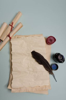 Kuzgun tüyü, mürekkep hokkası ve kırmızı arka planda eski sarı kağıt. Uzayı kopyala Eski mektup.