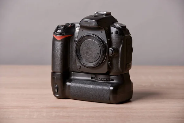 Digital photo camera on wooden desk table