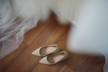 Gelin beyaz düğün ayakkabıları gösteriyor. Düğün ayrıntıları. Kapat.