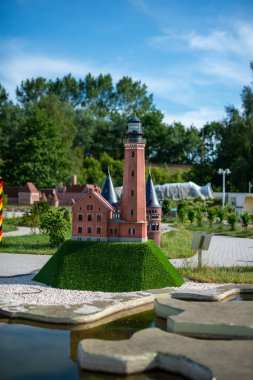 oyuncak deniz feneri, tuğla oyuncak deniz feneri ve kumsal geçmişi olan sarı yelkenli.