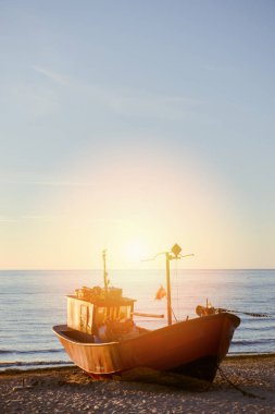 Gün doğumunda sahilde balıkçı tekneleri.