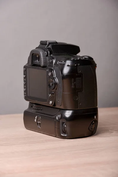 Digital photo camera on wooden desk table