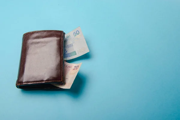 ブラウンマンレザー財布お金札付き青の背景 — ストック写真
