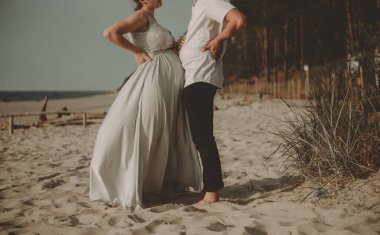 Gelin ve damat doğadaki bir fotoğraf çekiminde. Baltık Sahili.