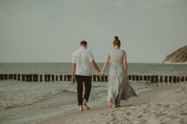 Gelin ve damat doğadaki bir fotoğraf çekiminde. Baltık Sahili.