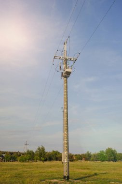 Çayırda yüksek voltajlı elektrik direği yapısı