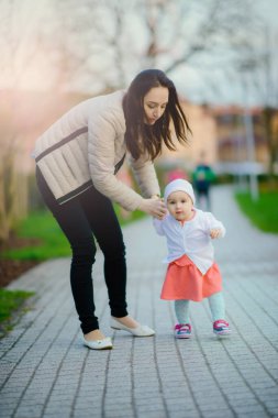 Parktaki mutlu anne ve kız. Aile hayatı olan güzel doğa manzarası. Mutlu bir aile yeşil çimlerin üzerinde birlikte dinleniyor, dışarıda eğleniyor. Aile hayatında mutluluk ve uyum..