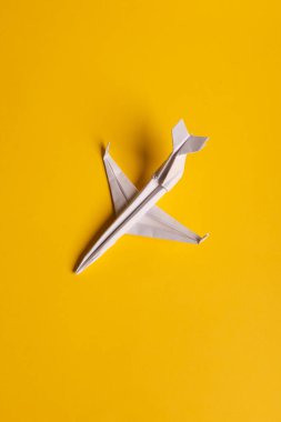Tek yönlü kağıt uçak grubu ve sarı arka planda farklı yönleri gösteren tek bir kişi. Yenilikçi çözüm konsepti işi. Uçak kuyruğundan noktalı çizgi.