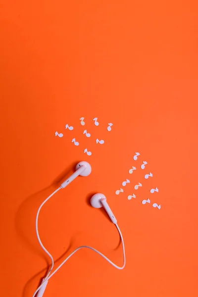 Weiße Kopfhörer Und Notizen Aus Weißem Papier Auf Orangefarbenem Hintergrund — Stockfoto