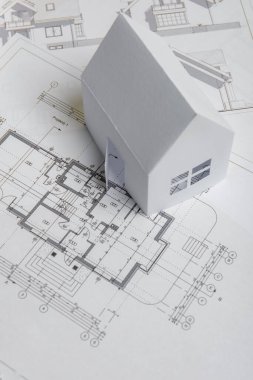 Beyaz aile kağıt evi, ev projeleri planı ve sarı arkaplan kağıdının planları. Minimalist ve basit bir kavram, tarz. Dikey yönelim.
