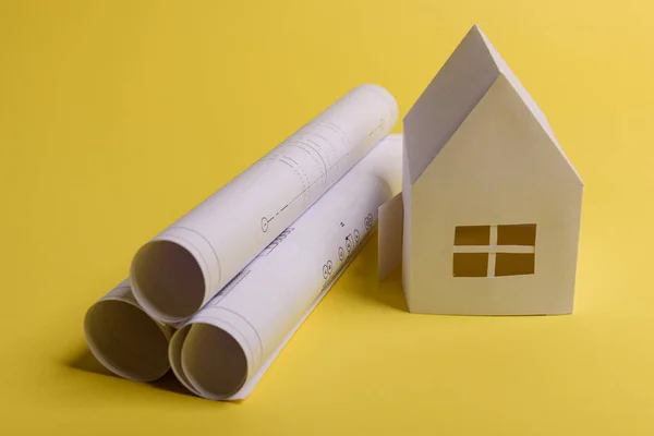 白色家庭用纸房子 房子项目计划和蓝图的黄色背景文件 简约简朴的概念风格纵向方向 — 图库照片