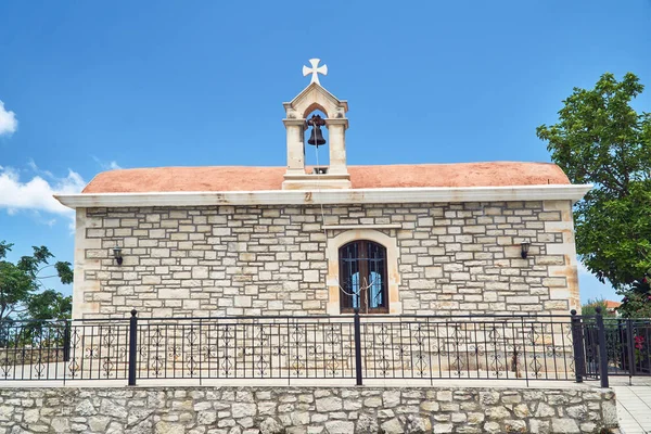 A stone Orthodox church with a bell tower on the island of Crete