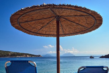 Lefkada Yunan Adası kayalık bir plajda saman şemsiye