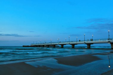 A concrete pier on the shore of the Baltic Sea in the city of Kolobrzeg clipart