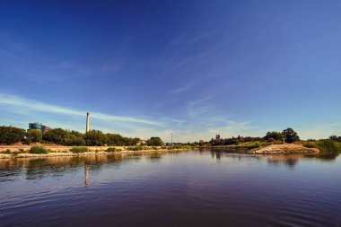 Poznan şehrinde Warta Nehri kıyısında bacalar ve binalar