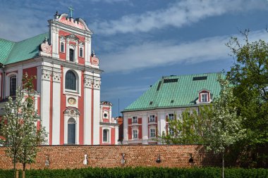 Poznan'da çiçek açan ağaçlar, ortaçağ duvarı ve barok bir kilise ve manastır