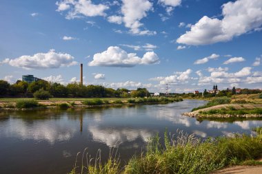 Poznan şehrinde Warta Nehri kıyısında bacalar ve binalar