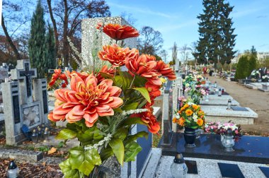 Flowers and candles on graves in a cemetery in Poland clipart