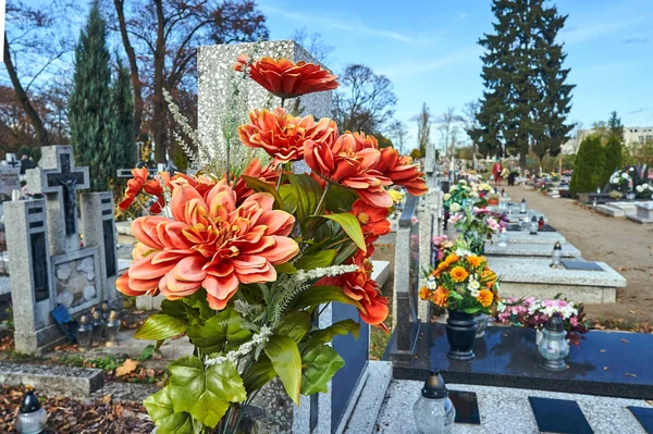 Flowers and candles on graves in a cemetery in Poland