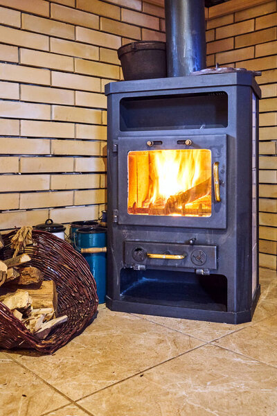 Flames of fire in a cast-iron stove in a corner of the room in Poland