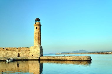 Girit adasındaki Rethymnon limanında taş duvar ve tarihi deniz feneri