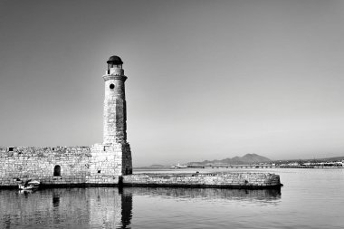 Girit adasındaki Rethymnon limanında taş duvar ve tarihi deniz feneri, siyah ve beyaz