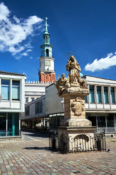 The historic figure of St. John of Nepomuk and the town hall tower in the market square in Poznan