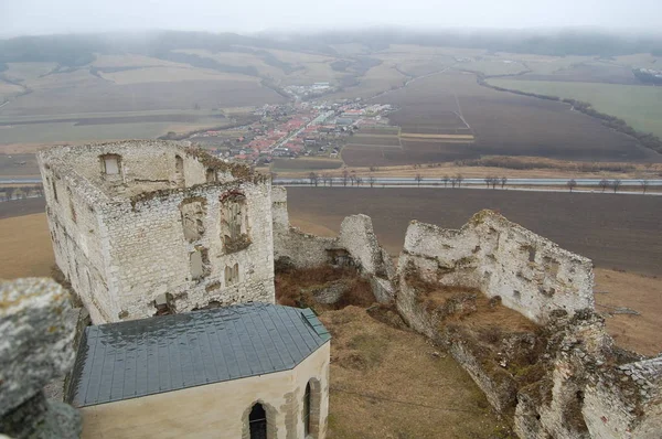 aerial view of historical stone ruins from old castle and meadows under grey sky