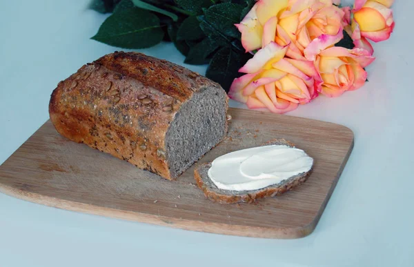 Pão Centeio Com Manteiga Tábua Madeira Rosas Mesa — Fotografia de Stock