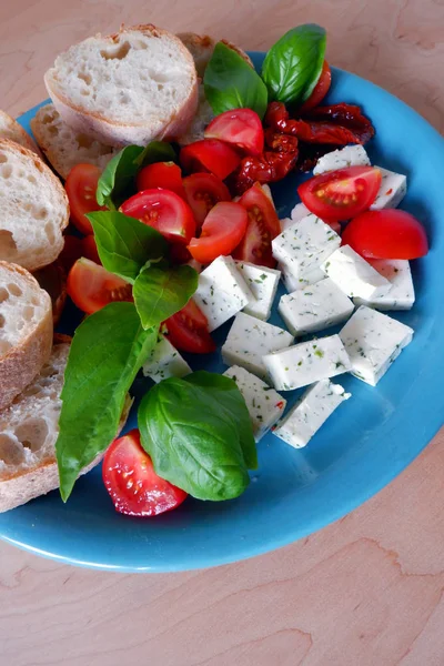 Piring Biru Dengan Keju Kambing Tomat Daun Kemangi Segar Dan — Stok Foto