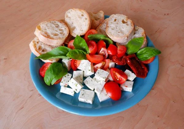 Niebieski Talerz Kozim Serem Pomidorem Świeżymi Liśćmi Bazylii Białym Chlebem — Zdjęcie stockowe