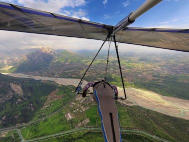 Cesur aşırı hang glider pilot sinekler yüksek üzerinde Vadisi nehir ve dağ Gemona, İtalya