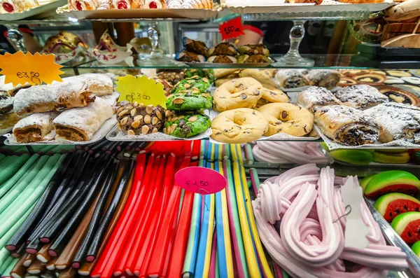 Multiple sweets on the shop shelves with price tags. Popular street food in Italy