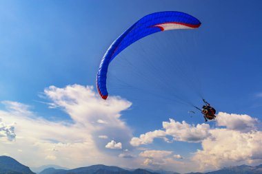 2018-08-23, Saint-Vincent-les-Forts, Fransa. Tandem paraşütler ile güzel bulutlar arka plan üzerinde uçmak. Fransa'da yaz