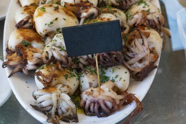 Izgara ahtapot bir plaka üzerinde boş bir fiyat etiketi ile. Seçme sokak deniz ürünleri. 