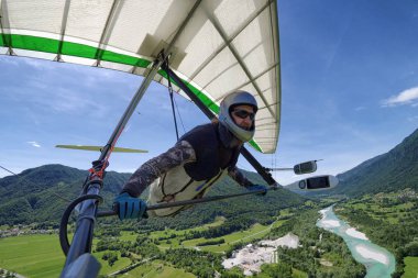 Selfie atış cesur aşırı hang glider pilot eylem fotoğraf makinesi ile çekilen zümrüt Nehri ile termal süzülürler alp Vadisi üzerinde yükselen