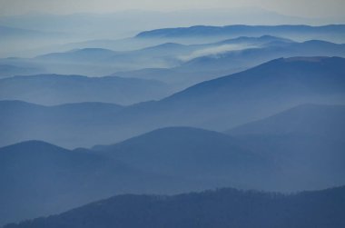Çok güzel bir sabah alp manzara ton bakış açısı ile. Sisli vadilerinin mavi tonalite dağlar deniz dalgaları gibi bak