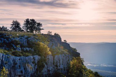 Kayalık dağ tepe ve sihirli pembe günbatımı. Akşam dağlarda