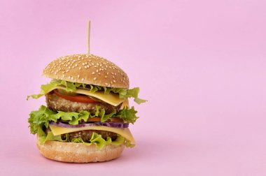 Duble çizburger pembe bir arka plan üzerinde