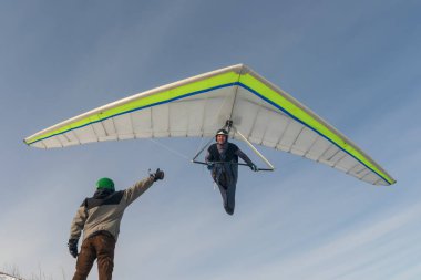 Gülümseyen Hang planör pilot kanat düşük zemin üzerinde sinek.